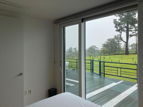 济州市Bibidoongdoong的一间卧室享有木甲板的景色