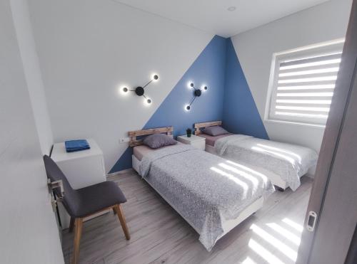 考纳斯K-Town - Apartments ViaBaltic Kaunas的一间卧室设有两张床和蓝色的墙壁