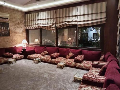 麦地那استراحة ريف طيبة的客厅配有红色沙发及枕头