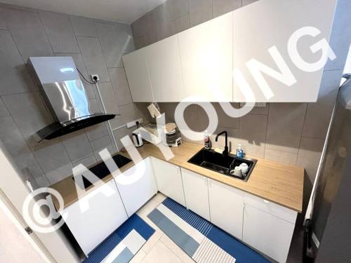 莎阿南Geo Bukit Rimau Apartment的厨房配有白色橱柜、水槽和镜子