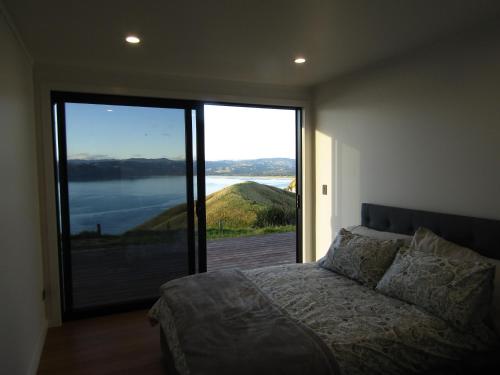 MahiaOcean Waters的一间卧室设有一张床和一个大型滑动玻璃门