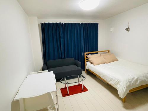 横须贺市STUDIO YONEGAHAMA l 米が浜通的一间卧室配有一张床、一把椅子和一张桌子