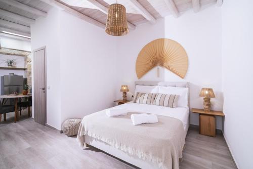 皮特斯迪亚Studio Papadia的白色卧室配有床和桌子