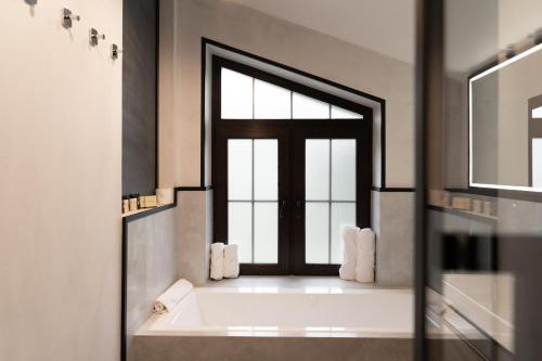 布克维Sherwood Chalet的带浴缸的浴室和窗户。