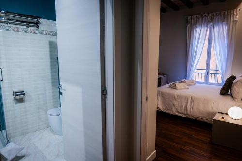 摩德纳Old Town - Boutique Rooms的一间卧室配有一张床,浴室设有淋浴。