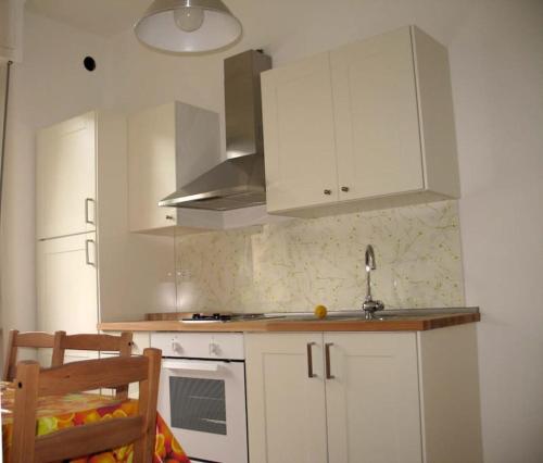 菲纳莱利古雷Apartment with private Garden的厨房配有白色橱柜和水槽