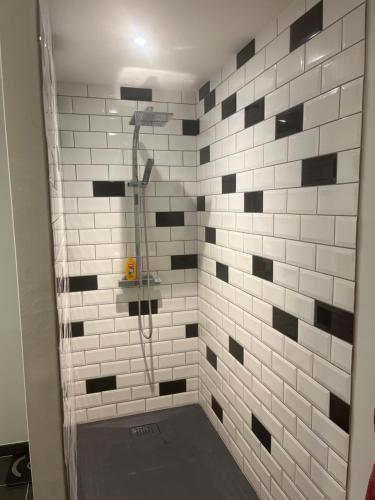 Pérignat-sur-Allierchambre où suite privative accès indépendant的浴室设有黑色和白色瓷砖和淋浴。