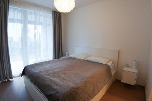 布拉格Holešovice Delight: Modern Comfort with a Twist in Prague 7的一间卧室设有一张床和一个大窗户