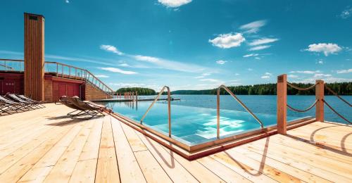 库奥皮奥Bella Lake Resort的水体旁的木甲板上的游泳池