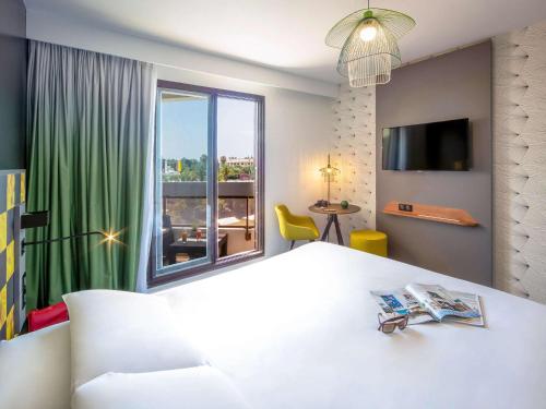 耶尔耶尔中心蔚蓝海岸美居酒店的卧室设有一张白色大床和大窗户