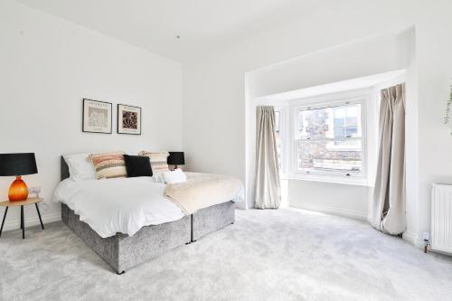卡迪夫StayRight Spacious Apartments with Private Parking- 15-Minute Stroll to Town Centre的白色的卧室设有床和窗户