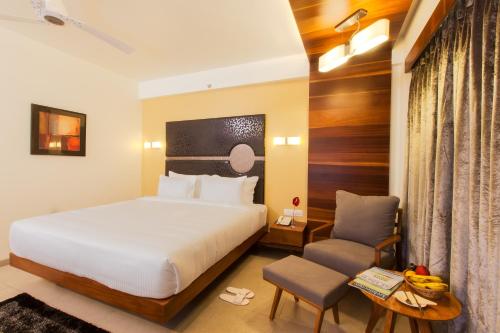 艾哈迈达巴德科斯莫普利谭酒店的配有一张床和一把椅子的酒店客房