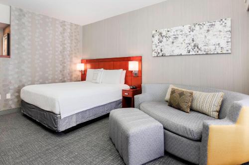 阿林顿达拉斯阿灵顿南万怡酒店的配有一张床和一把椅子的酒店客房