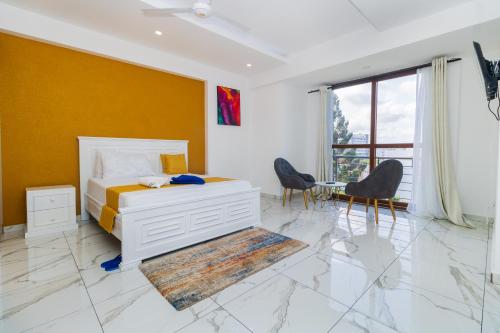 蒙巴萨Luxury 3br Ensuite Apt in Prestigious Nyali的一间卧室配有床和椅子,拥有黄色的墙壁