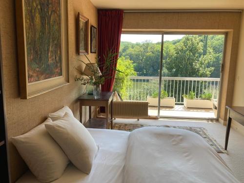 阿夫赖城Les Etangs的一间卧室设有一张床,享有阳台的景色