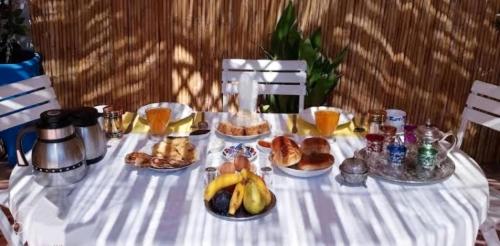 非斯Fes Antique Hostel的一张桌子,上面有白色的桌布,上面有早餐食品
