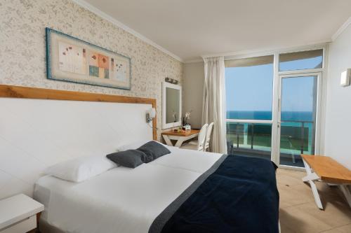内坦亚瑞兹丹斯酒店的卧室设有白色的床和大窗户