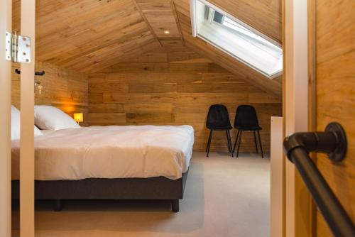 HaarleSallands huisje的一间卧室配有一张床和两张黑色椅子