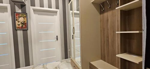 巴库Park Azure Comfortable Apartment的衣柜里,有白色的门和架子