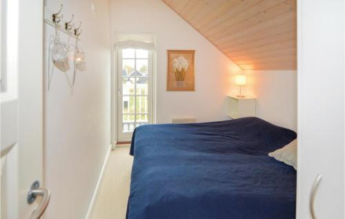 Gjern82号基恩公寓-带热水浴缸的一间卧室设有蓝色的床和窗户。