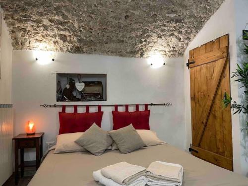 Capistrello'Il Caratteristico' (centro storico)的一间卧室配有一张带红色枕头的大床