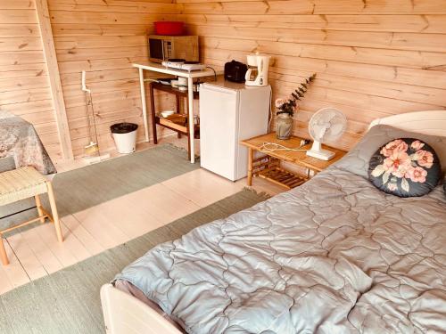 Lemmenjoki莱蒙鲁莫 - 自然体验与住宿露营地的客房设有一张床、一张书桌和一台冰箱