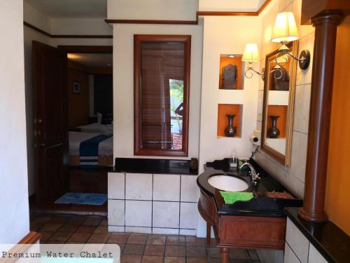 波德申Alpine LXPD Water Chalet的一间带水槽和镜子的浴室以及一张床