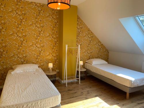 阿尔贝COTTAGE DU PARC的黄色墙壁的客房内的两张床