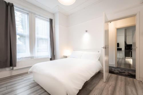 南安普敦Newly Renovated 2 Bed Ground Floor Flat的白色的卧室设有一张白色大床和一个窗户。