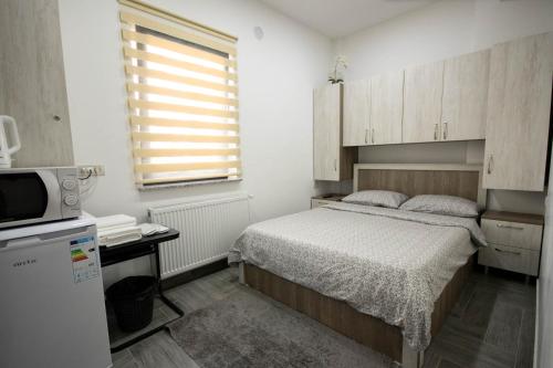 勒德乌齐AStar Apartments - SMALL的一间小卧室,配有一张床和一台微波炉