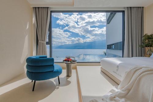 大理大理無双晴野·海景度假酒店（洱海店）的一间卧室设有蓝色椅子和大窗户