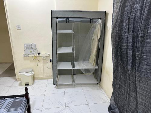 沙迦Room available in one bedroom appartment dating not allowd thare的设有带卫生间的浴室内的淋浴间
