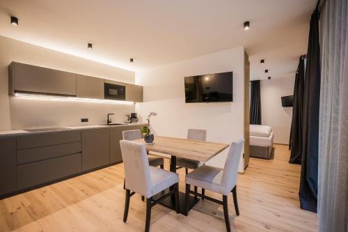 维拉巴萨Montanaris Alpine - Active - Relax的厨房以及带木桌和椅子的用餐室。