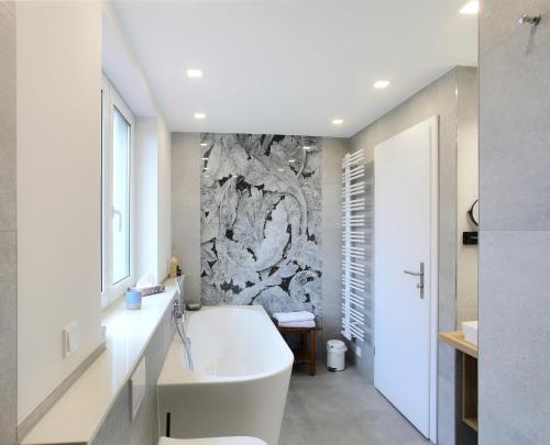 德累斯顿Haus Welzel的浴室配有白色浴缸和石墙