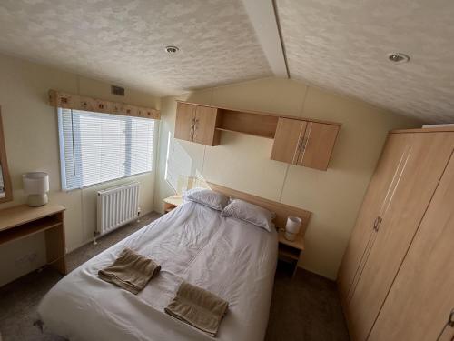 滨海克拉克顿Lovely 2-Bed Lodge in St Osyth的一间小卧室,配有床和窗户