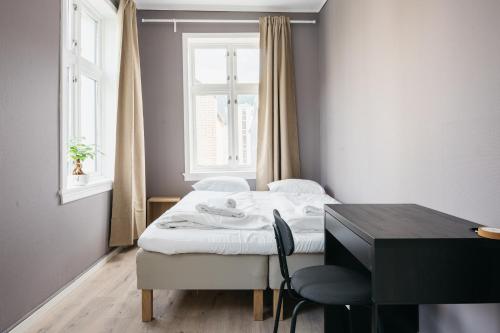 卑尔根S54 - Private Rooms in the City Center的一间卧室配有一张床、一张书桌和一个窗户。