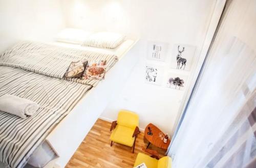 索波特Sopot Retro Apartment的一间小卧室,配有一张床和一张黄色椅子