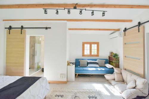 拉蒂尔比耶Wood Chalet 1 Monaco Forest La Turbie - Sleeps 5 people的一间卧室配有蓝色的沙发和一张床