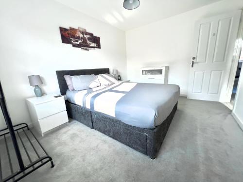 Mile EndNorth Colchester Homestay的一间卧室配有一张大床和一个床头柜