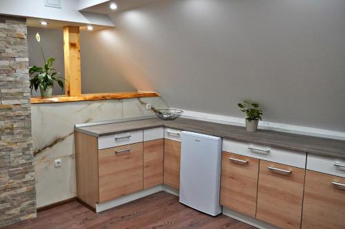拉夫纳格拉Apartman Tilia的厨房配有白色冰箱和木制橱柜。
