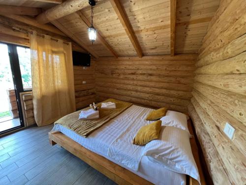 SălătrucelM&V Infinit的木制客房内的一间卧室,配有一张床