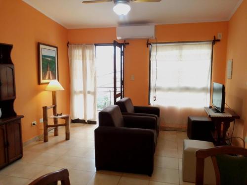 波萨达斯Costa Posadas的带沙发和电视的客厅以及2扇窗户。