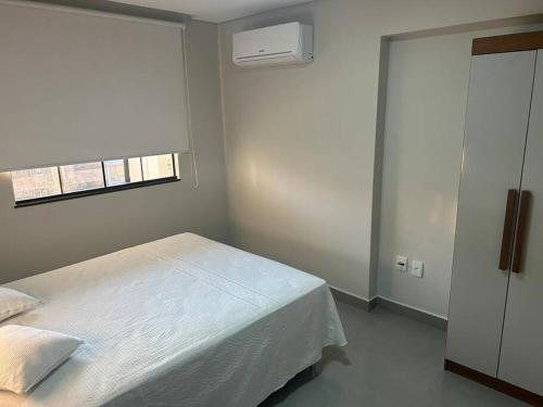 圣洛伦索Apartamento aconchegante no centro de São Lourenço的卧室配有白色的床和窗户。