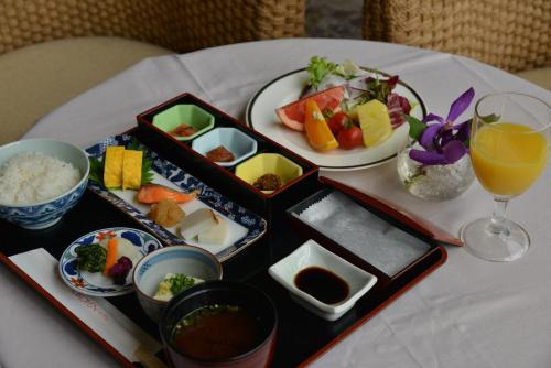 久留米市Suikouen Hotel的餐桌,盘子和一杯橙汁