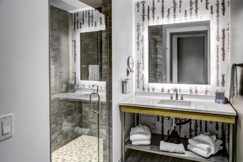 普莱瑟维尔Red Hawk Resort & Casino的一间带两个盥洗盆和淋浴的浴室