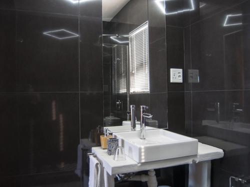 吕德里茨Wildhorses B&B and Self Catering的浴室设有白色水槽和镜子