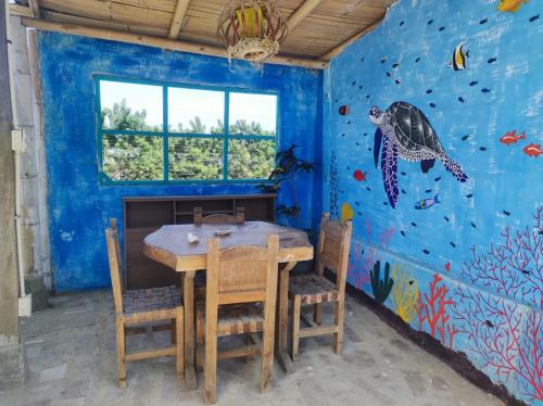 马查利亚Guest House Villa Machalilla的一间带桌子和海龟壁画的用餐室