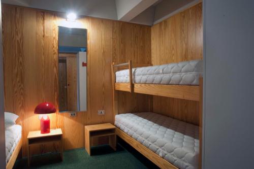 马里尔伊瓦Ale1206 Marilleva 1400的小房间设有两张双层床和一盏灯。