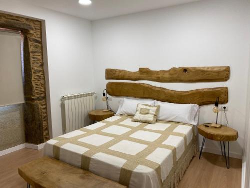 TouroCasa Fontes Rosas的一间卧室配有一张大床和木制床头板