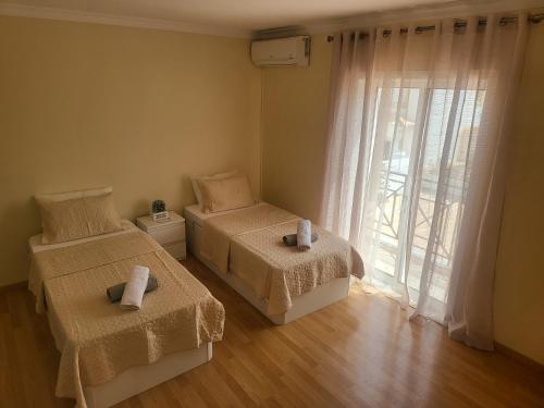 阿尔布费拉Flor do Campo的一间卧室设有两张床和大窗户